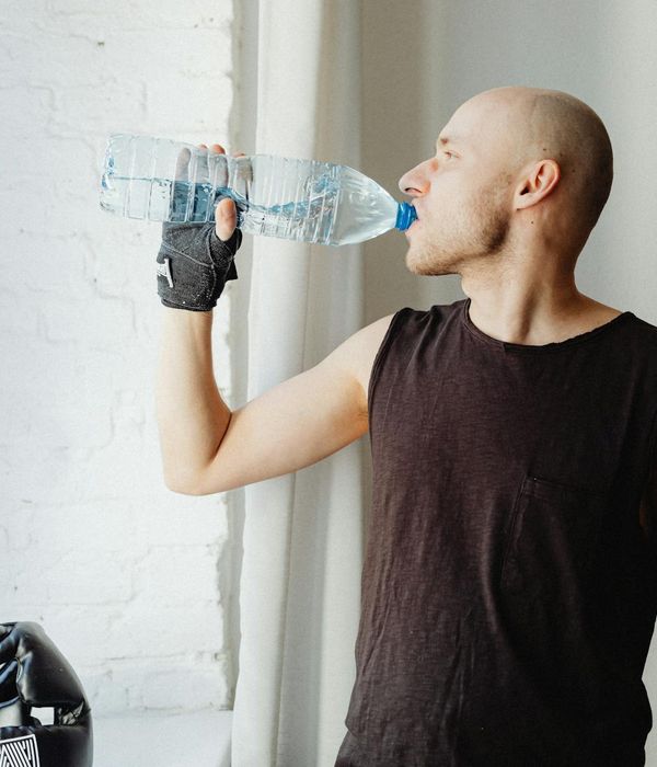 Man performing a controlled strength exercise in a dark, focused environment.